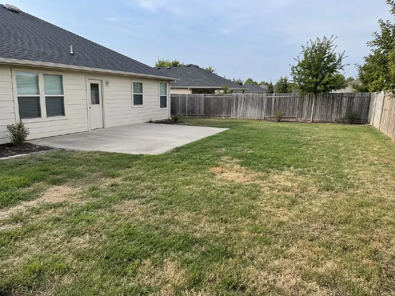 Original patio photo with existing paving, lawn and fences